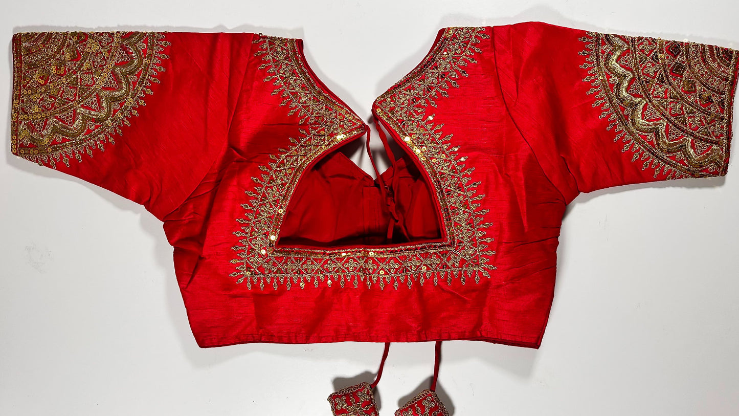 Back view of red silk blouse showing tie-up design with embroidered tassels and detailed traditional bridal embroidery work