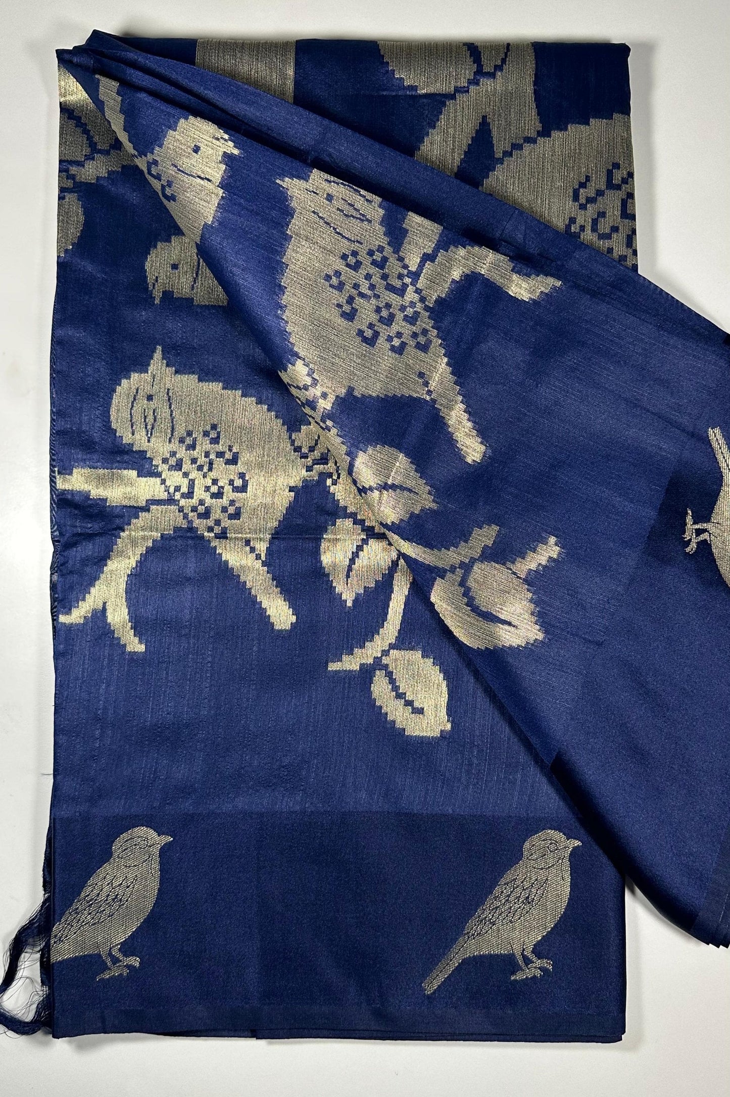 Royal blue silk saree with woven bird and floral motifs showing nature-inspired traditional Indian design and lustrous silk fabric quality