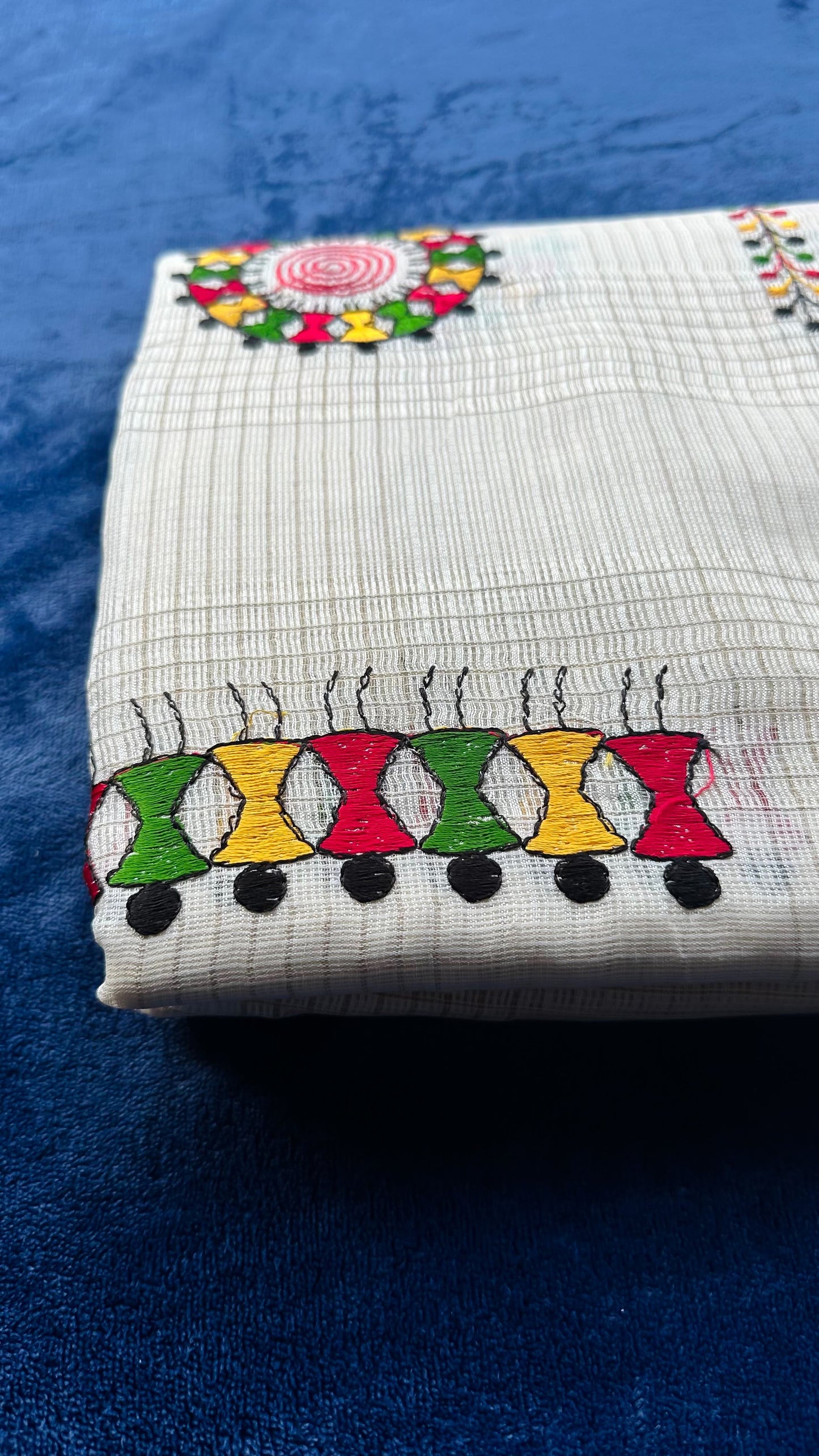 Hand-embroidered cotton saree with colorful folk art motifs showing traditional Indian handloom fabric and artisan embroidery work