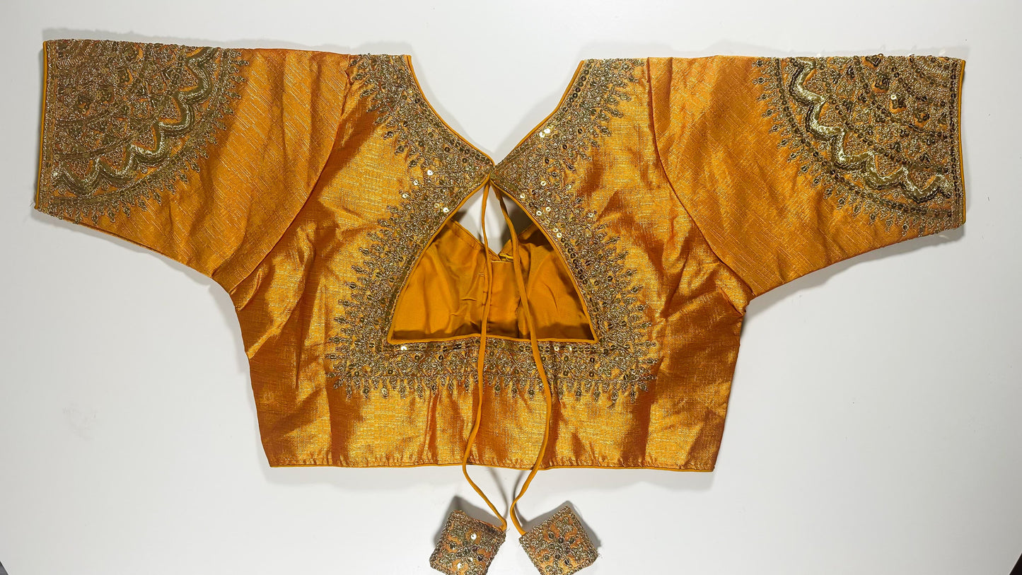 Back view of golden silk blouse showing tie-up design with embroidered tassels and detailed traditional embroidery work