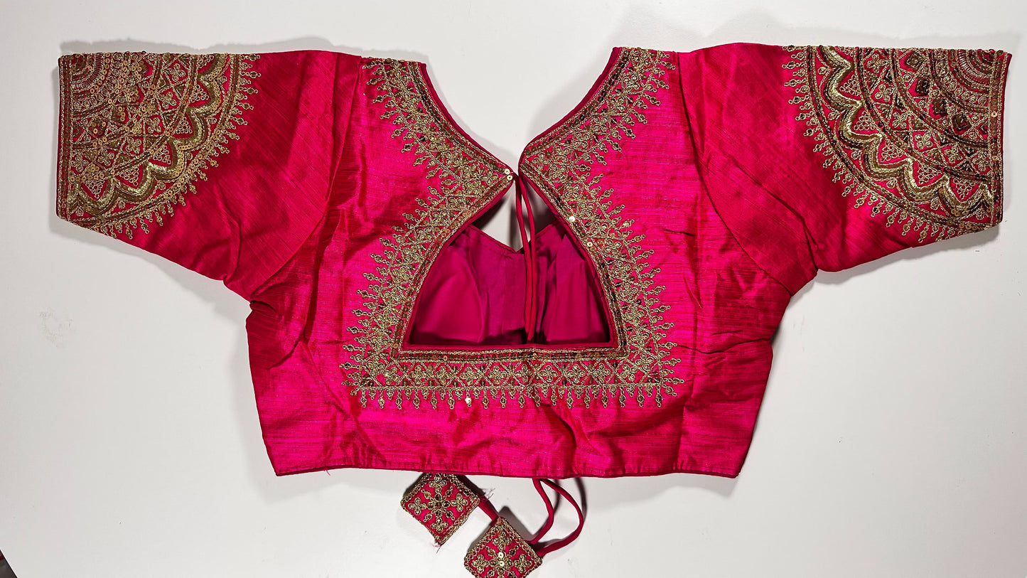 Back view of pink silk blouse showing tie-up design with embroidered tassels and detailed traditional embroidery work