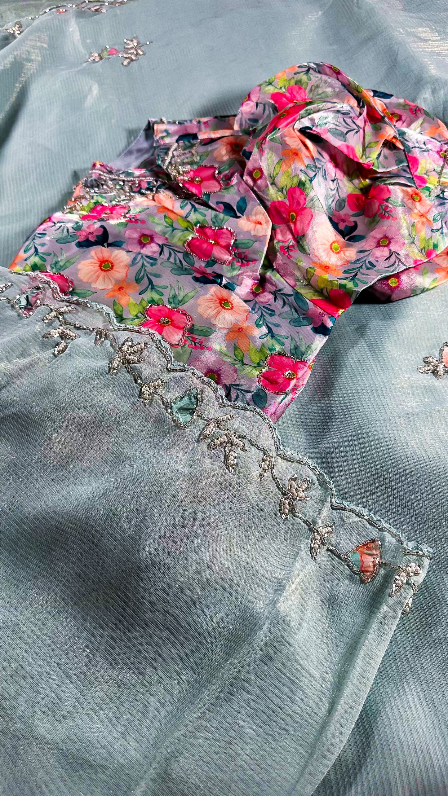 Mint blue silk saree with delicate floral embroidery and crystal work border detail showing traditional Indian craftsmanship