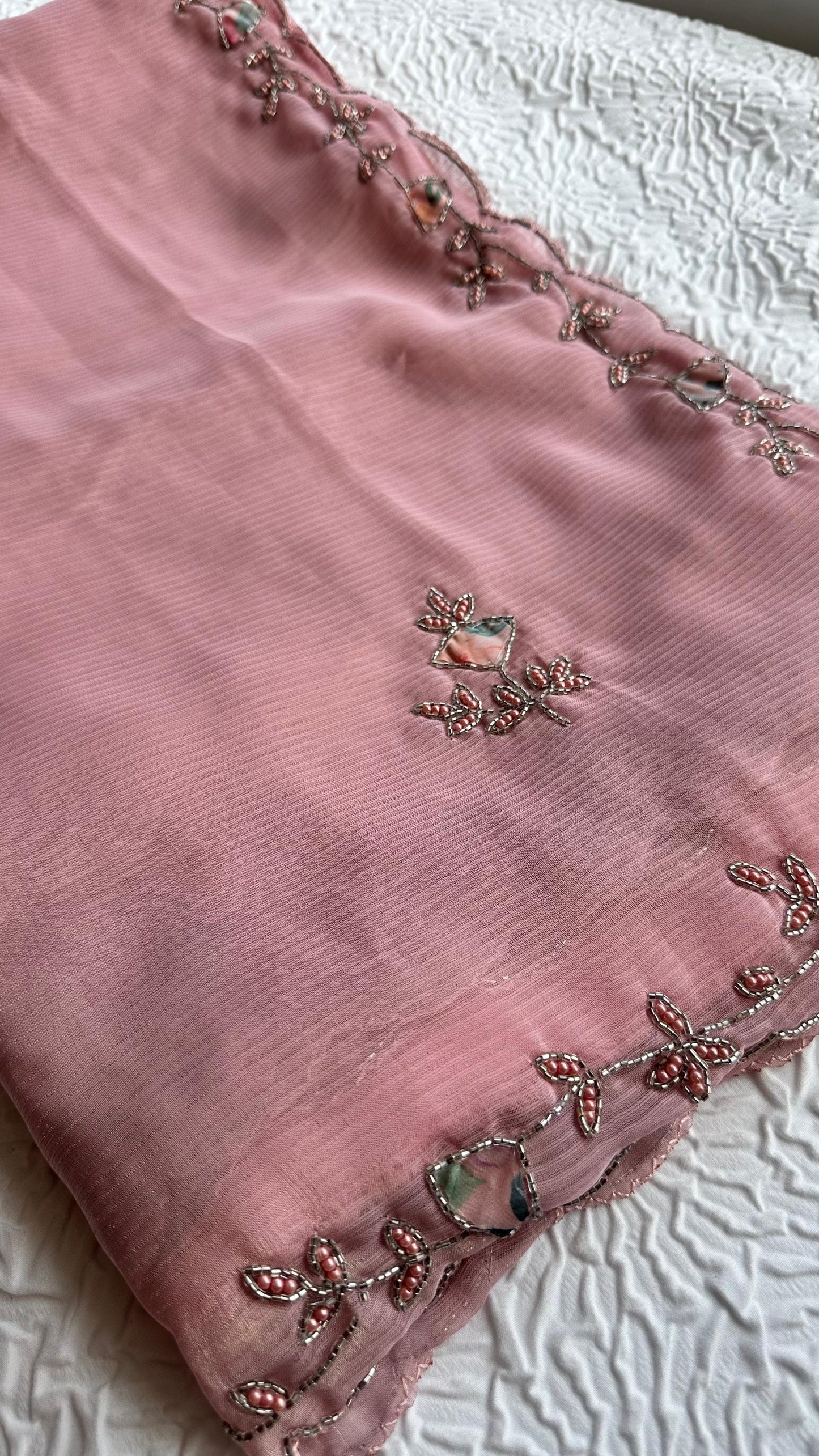 Model wearing pastel pink embroidered saree with printed floral blouse.