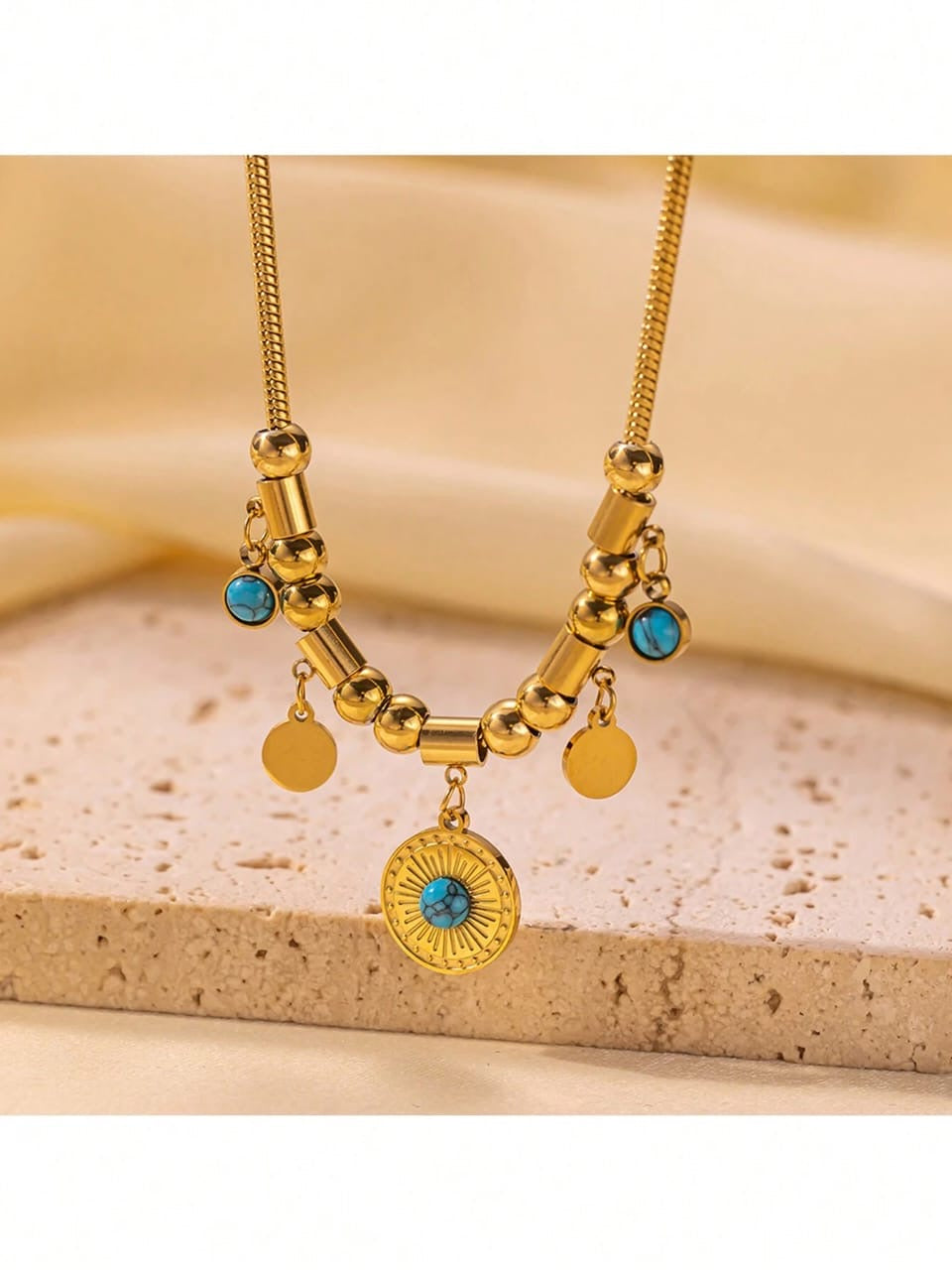 Bohemian gold statement necklace with turquoise stone accents, textured medallion and mixed coin charms on snake chain - artisanal designer jewellery UK