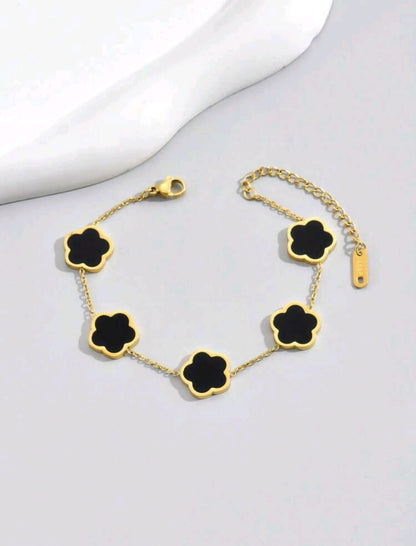 Sophisticated gold chain bracelet with five black onyx clover motifs - elegant designer jewellery featuring genuine black stones for UK customers