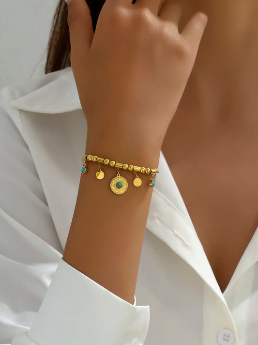 Bohemian gold charm bracelet with turquoise stone accents, textured disc and coin charms on beaded chain - artisanal designer jewellery for UK boho styling