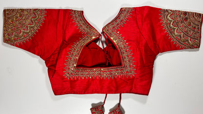 Back view of red silk blouse showing tie-up design with embroidered tassels and detailed traditional bridal embroidery work