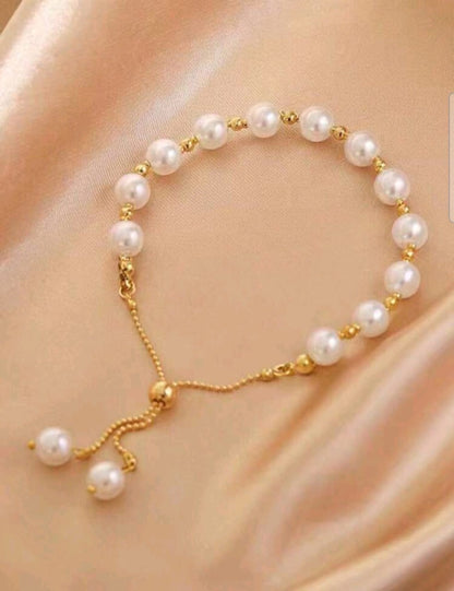 Elegant gold pearl adjustable slider bracelet with freshwater pearls and gold spacer beads featuring no-clasp design - luxury designer jewellery UK