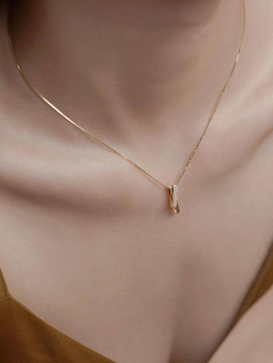 Minimalist gold curved horn pendant necklace with crystal pavé setting on delicate chain - contemporary designer jewellery for UK customers