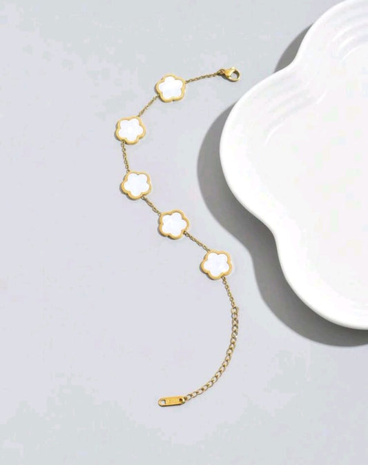 Elegant gold chain bracelet with five white mother of pearl clover motifs - luxury designer jewellery featuring natural iridescent stones for UK customers