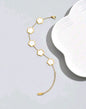 Elegant gold chain bracelet with five white mother of pearl clover motifs - luxury designer jewellery featuring natural iridescent stones for UK customers