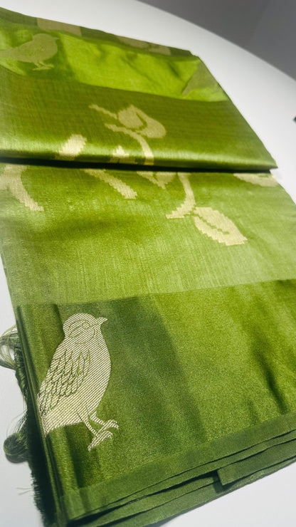 Green silk saree with woven bird and leaf motifs showing nature-inspired traditional Indian design and lustrous silk fabric