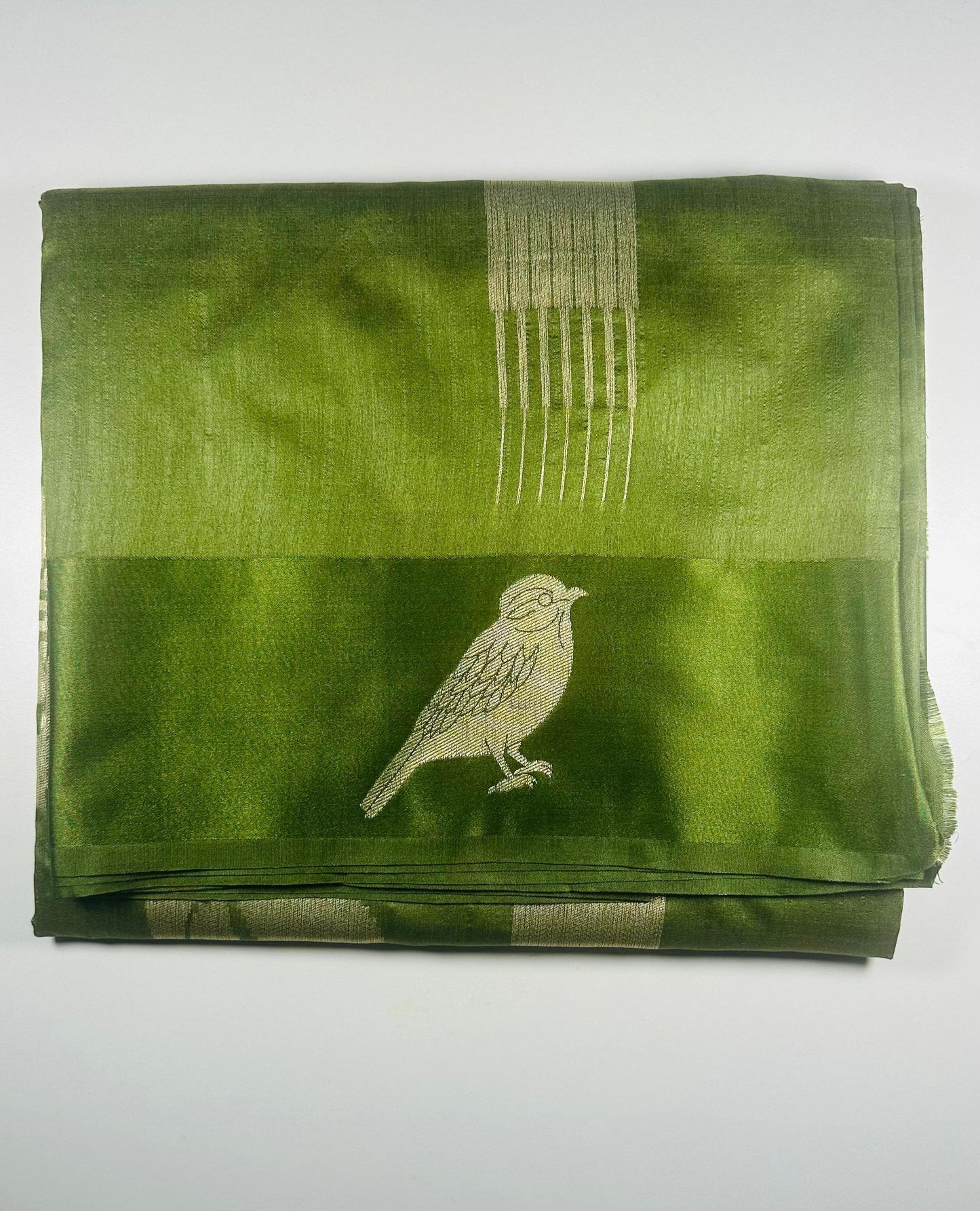 Green silk saree with woven bird and leaf motifs showing nature-inspired traditional Indian design and lustrous silk fabric