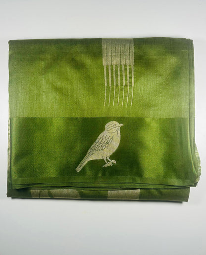 Green silk saree with woven bird and leaf motifs showing nature-inspired traditional Indian design and lustrous silk fabric