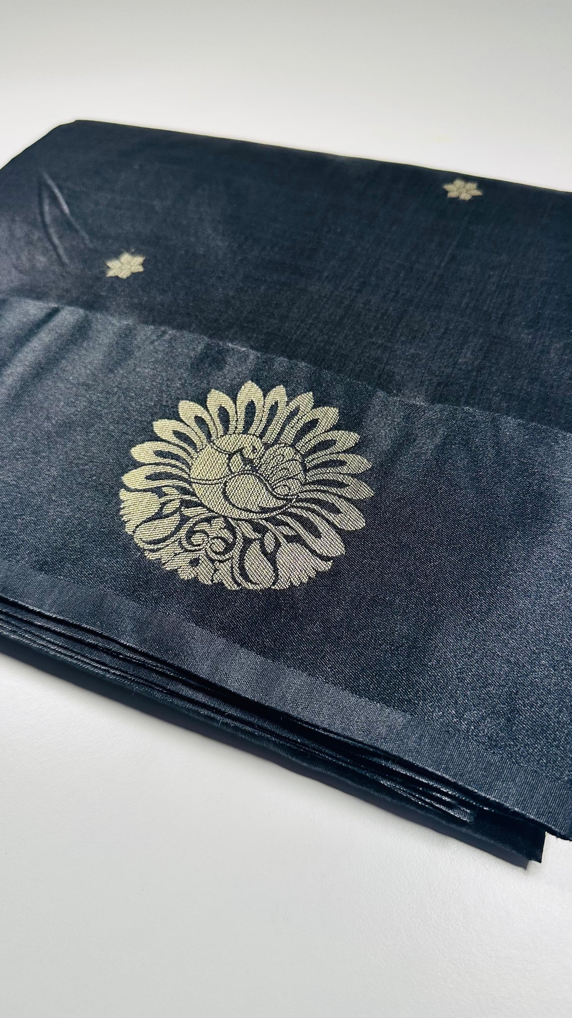 Black silk saree with gold woven floral motifs showing elegant traditional Indian design and luxurious silk fabric texture