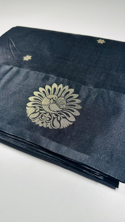 Black silk saree with gold woven floral motifs showing elegant traditional Indian design and luxurious silk fabric texture