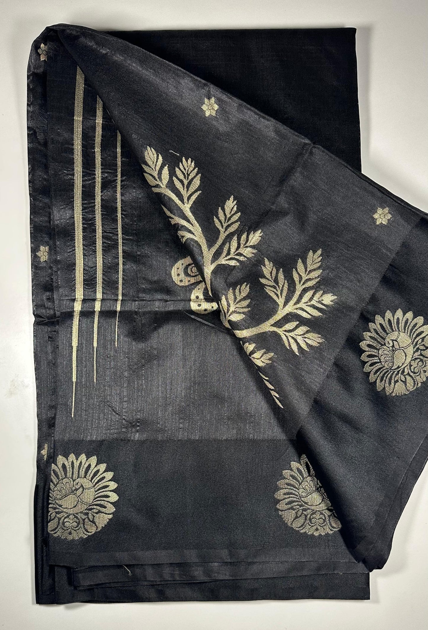 Black silk saree with gold woven floral motifs showing elegant traditional Indian design and luxurious silk fabric texture