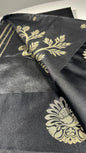 Black silk saree with gold woven floral motifs showing elegant traditional Indian design and luxurious silk fabric texture