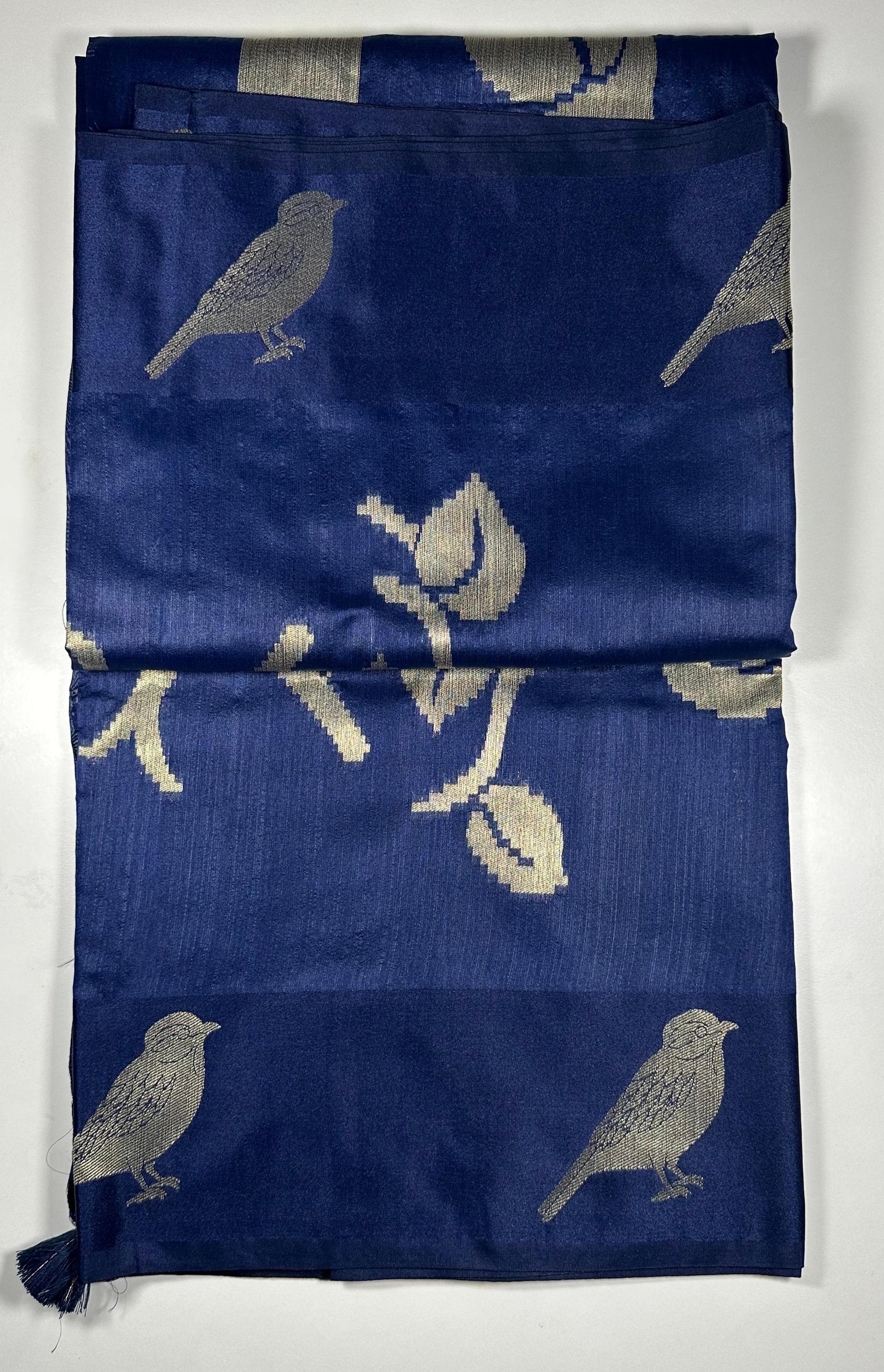 Royal blue silk saree with woven bird and floral motifs showing nature-inspired traditional Indian design and lustrous silk fabric quality