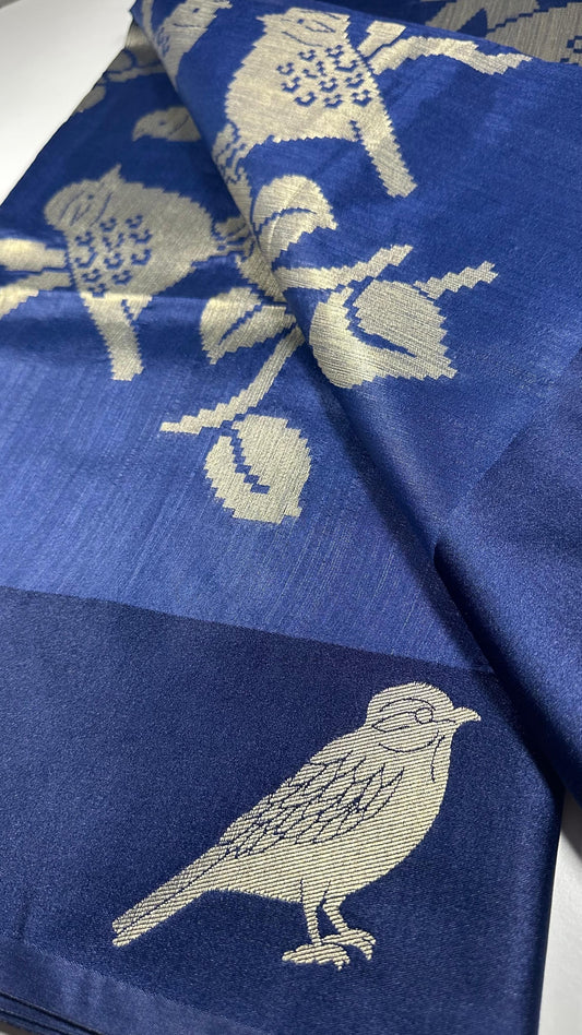 Royal blue silk saree with woven bird and floral motifs showing nature-inspired traditional Indian design and lustrous silk fabric quality