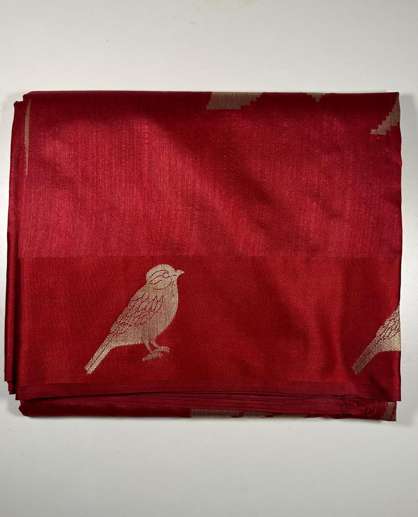  Red silk saree with woven bird and floral motifs showing traditional Indian wedding design and lustrous silk fabric with gold zari work