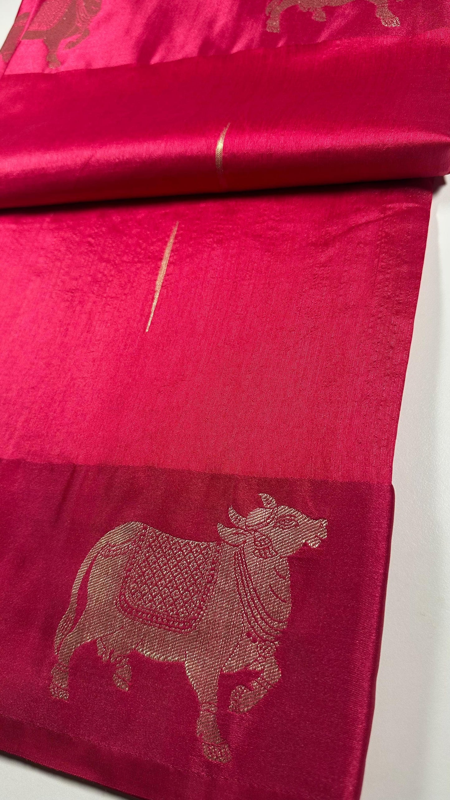 Traditional Hindu magenta silk saree with sacred cow motifs displayed showing religious and festival wear quality