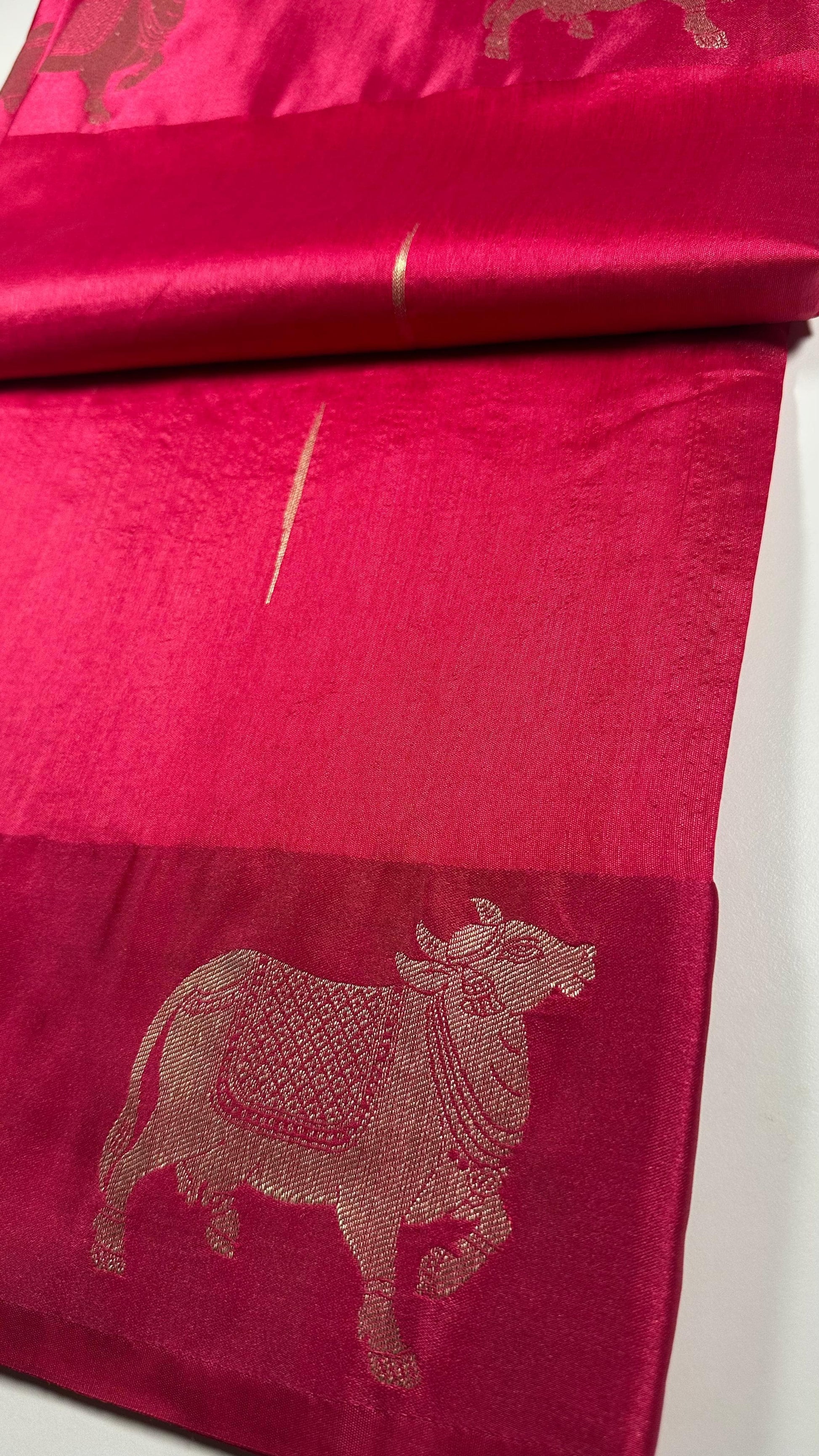 Traditional Hindu magenta silk saree with sacred cow motifs displayed showing religious and festival wear quality