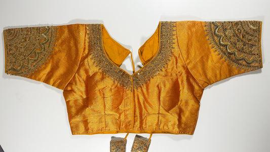 Golden embroidered saree blouse with heavy zardozi work showing traditional Indian bridal choli design with intricate handwork
