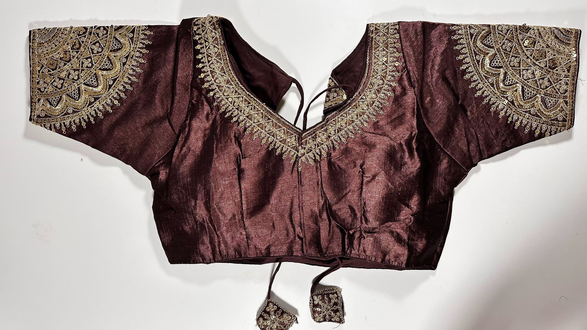 Maroon embroidered saree blouse with heavy zardozi work showing traditional Indian bridal choli design with intricate gold handwork