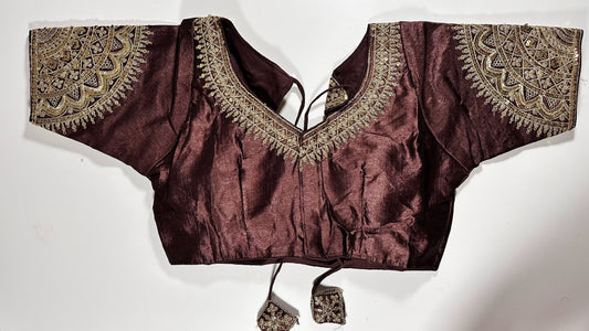 Maroon embroidered saree blouse with heavy zardozi work showing traditional Indian bridal choli design with intricate gold handwork