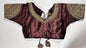 Maroon embroidered saree blouse with heavy zardozi work showing traditional Indian bridal choli design with intricate gold handwork