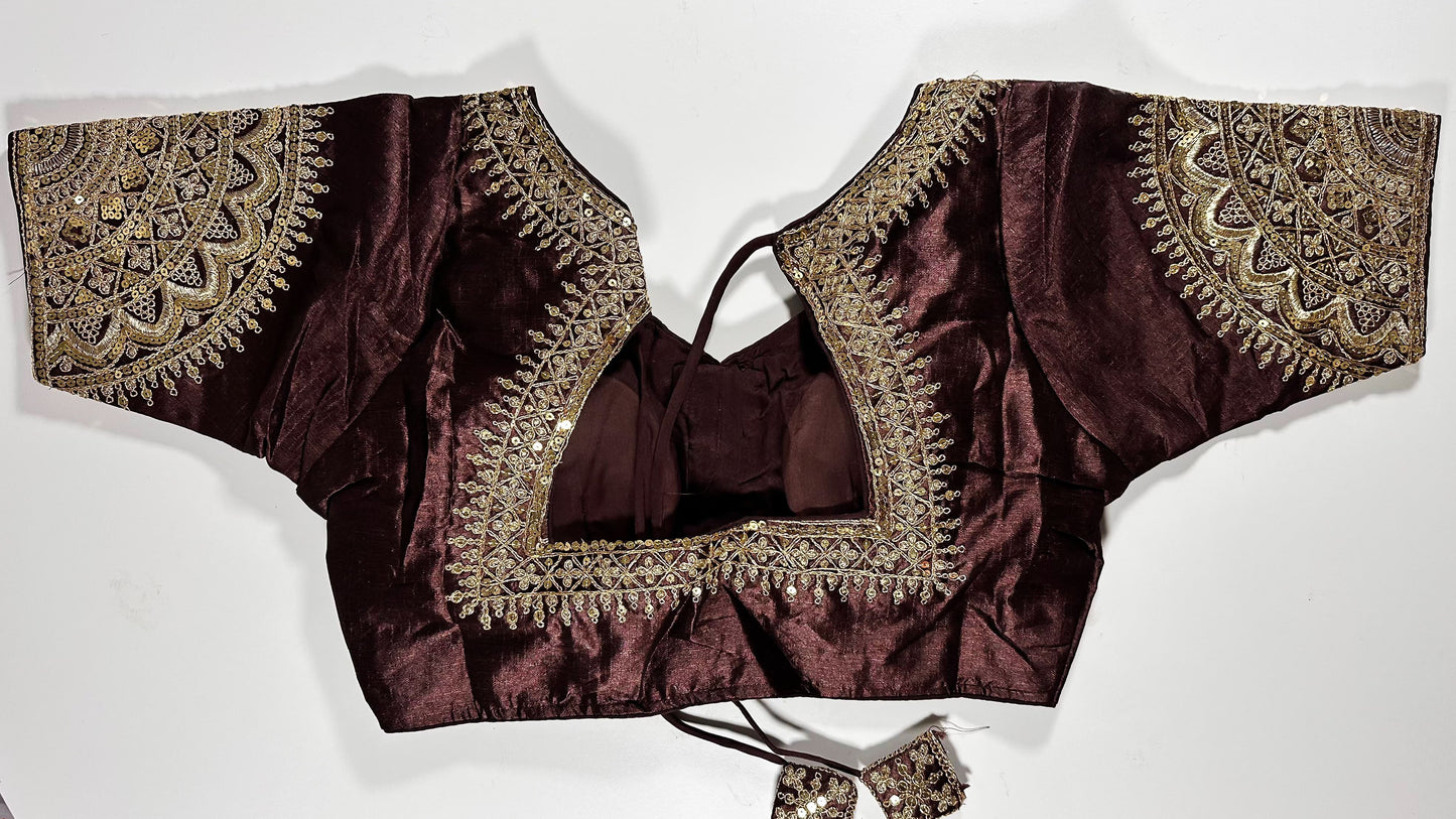 Back view of maroon silk blouse showing tie-up design with embroidered tassels and detailed traditional embroidery work