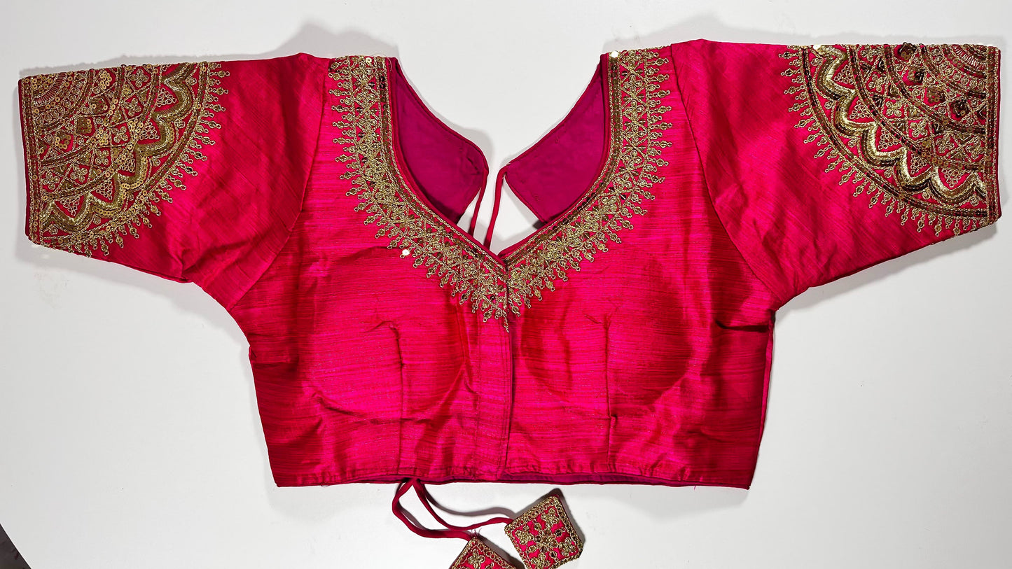 Bright pink embroidered saree blouse with heavy zardozi work showing traditional Indian bridal choli design with intricate gold handwork