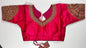Bright pink embroidered saree blouse with heavy zardozi work showing traditional Indian bridal choli design with intricate gold handwork