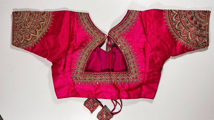 Back view of pink silk blouse showing tie-up design with embroidered tassels and detailed traditional embroidery work