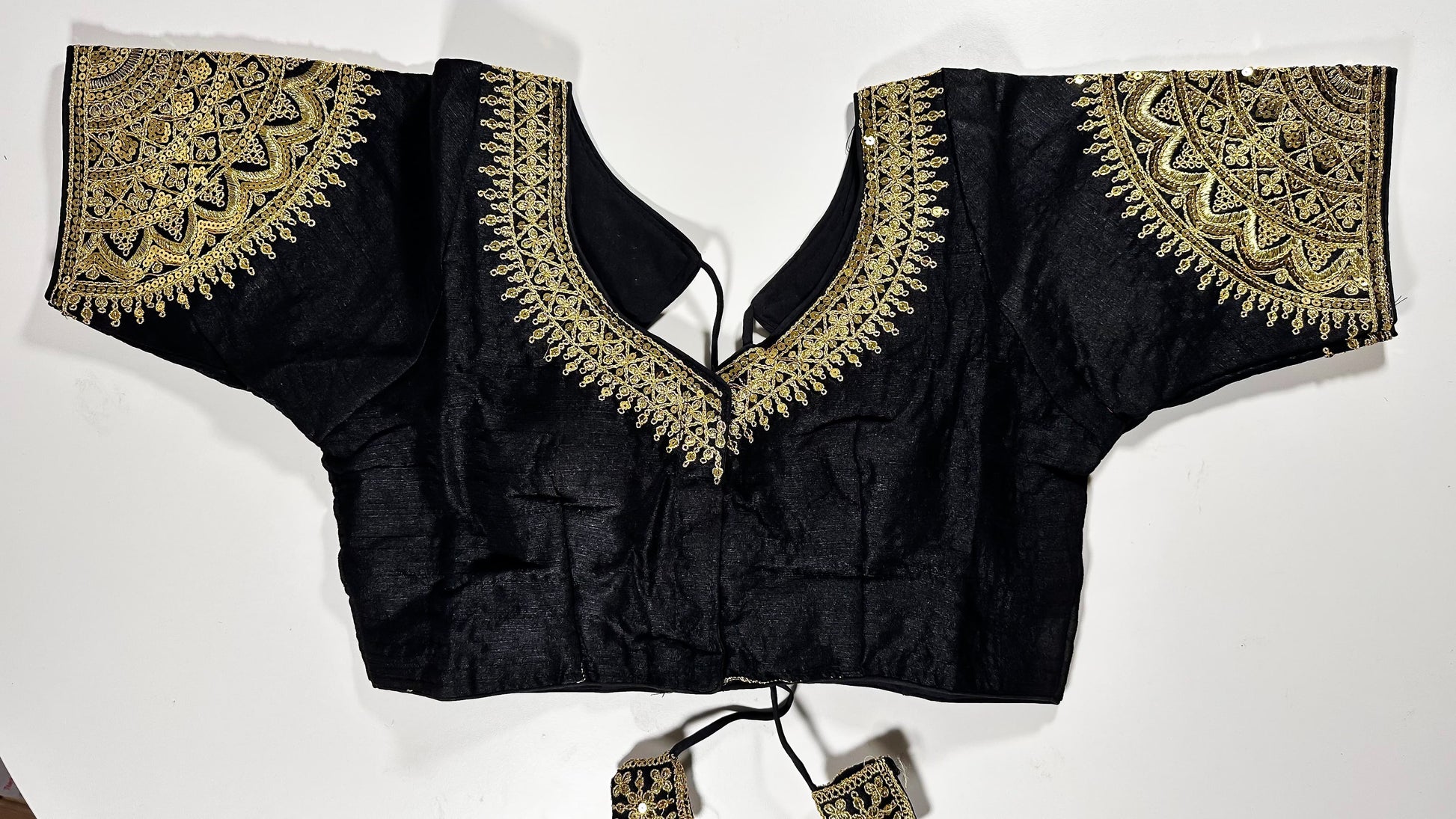 Black embroidered saree blouse with heavy zardozi work showing traditional Indian designer choli with intricate gold handwork