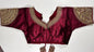 Wine maroon embroidered saree blouse with heavy zardozi work showing luxury Indian choli design with intricate gold handwork