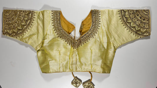 Luxury golden silk saree blouse with heavy zardozi embroidery featuring paisley motifs, deep V-neck design, and traditional Indian craftsmanship - front view