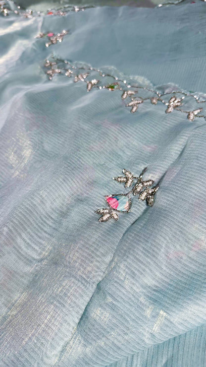 Detailed view of saree border embroidery with crystal embellishments and traditional vine patterns on silk fabric