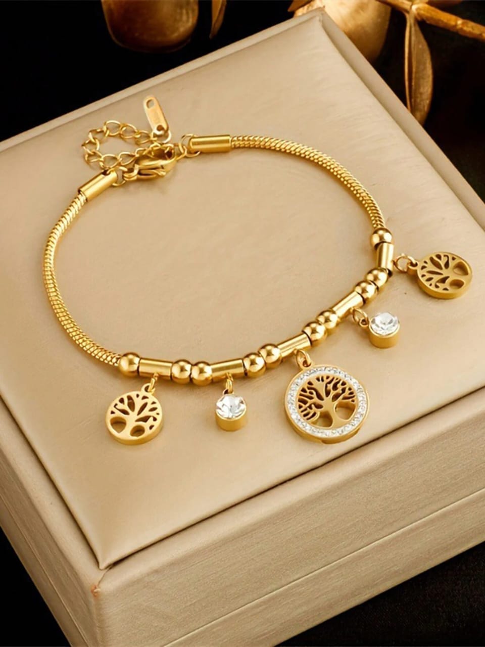 Gold Tree of Life charm bracelet with multiple symbolic tree pendants and crystal accents in elegant gift box - meaningful jewellery for UK customers