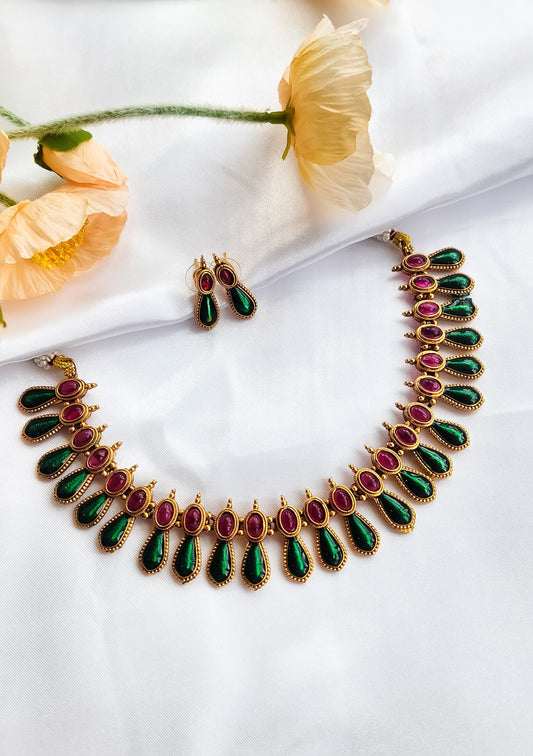 South Indian antique ruby-green heritage necklace set with matching earrings on white silk background