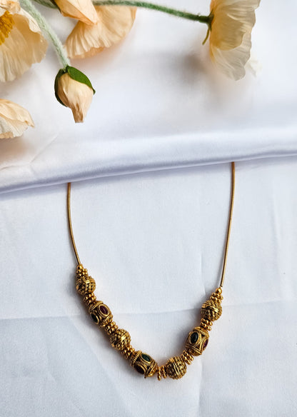 Antique beaded ball necklace with alternating red and green kemp stones on gold-plated wire, traditional South Indian temple jewelry design.