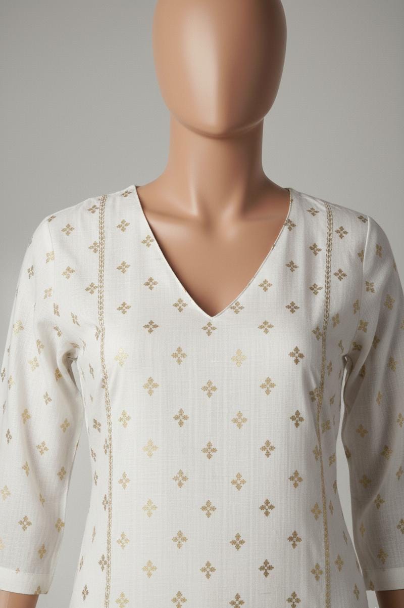 Mannequin wearing a white blouse with gold patterns on a plain background