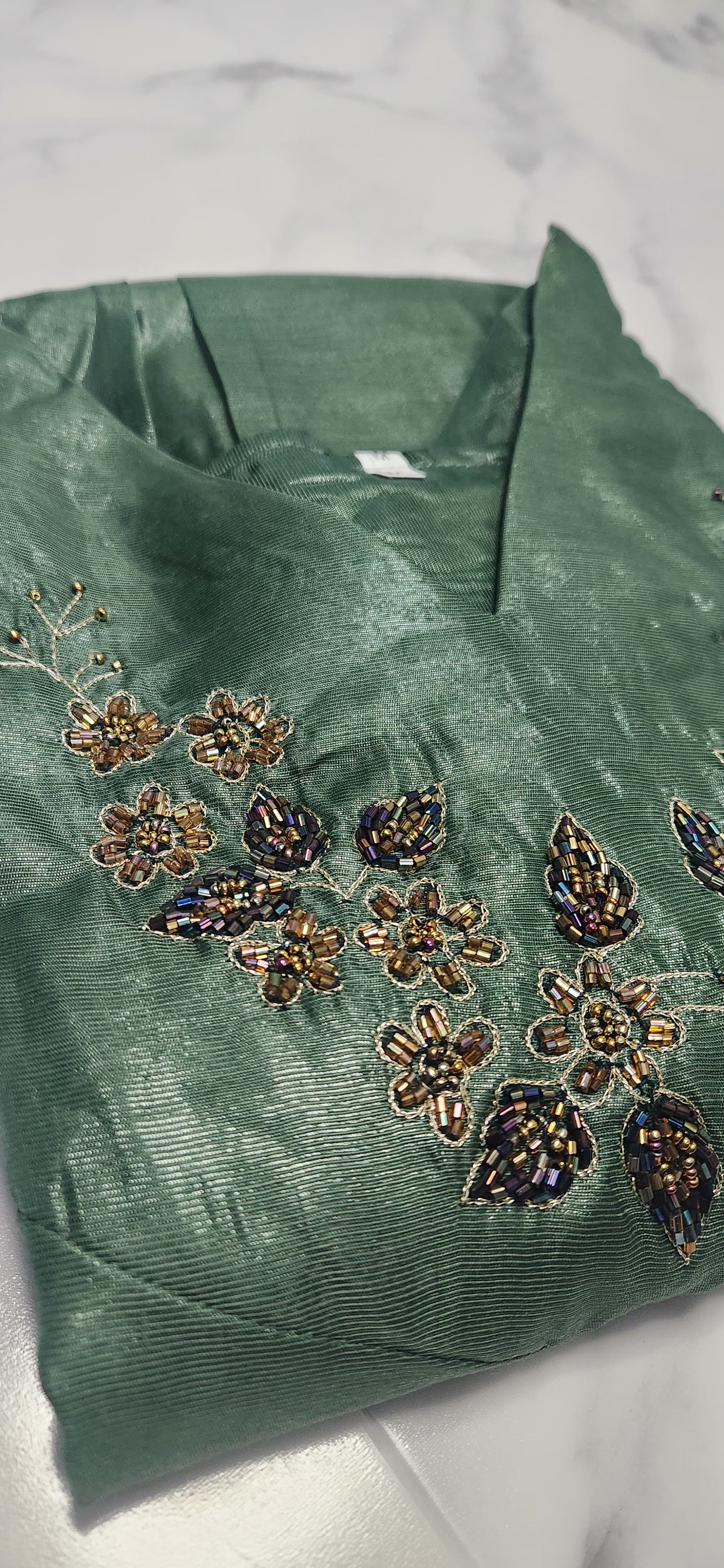 Emerald green silk embroidered dress with hand beadwork, V-neck design, and festive shimmer — elegant Christmas outfit for women.