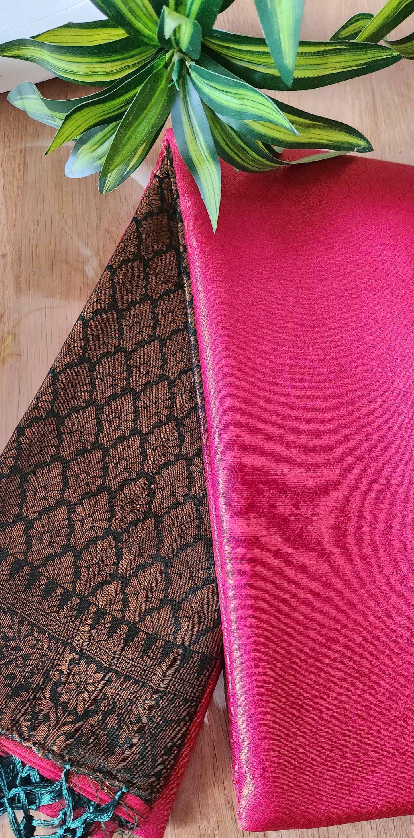 Kubera silk saree with a double-shaded woven silk body and intricately detailed traditional border, neatly styled on a wooden surface with minimal décor.