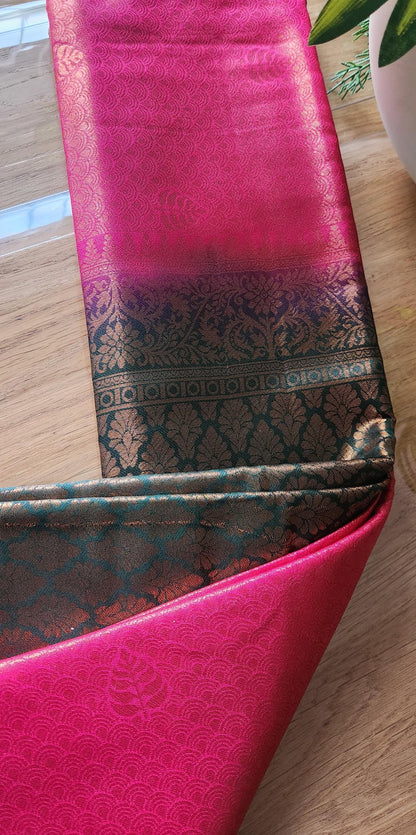 Kubera silk saree with a double-shaded woven silk body and intricately detailed traditional border, neatly styled on a wooden surface with minimal décor.