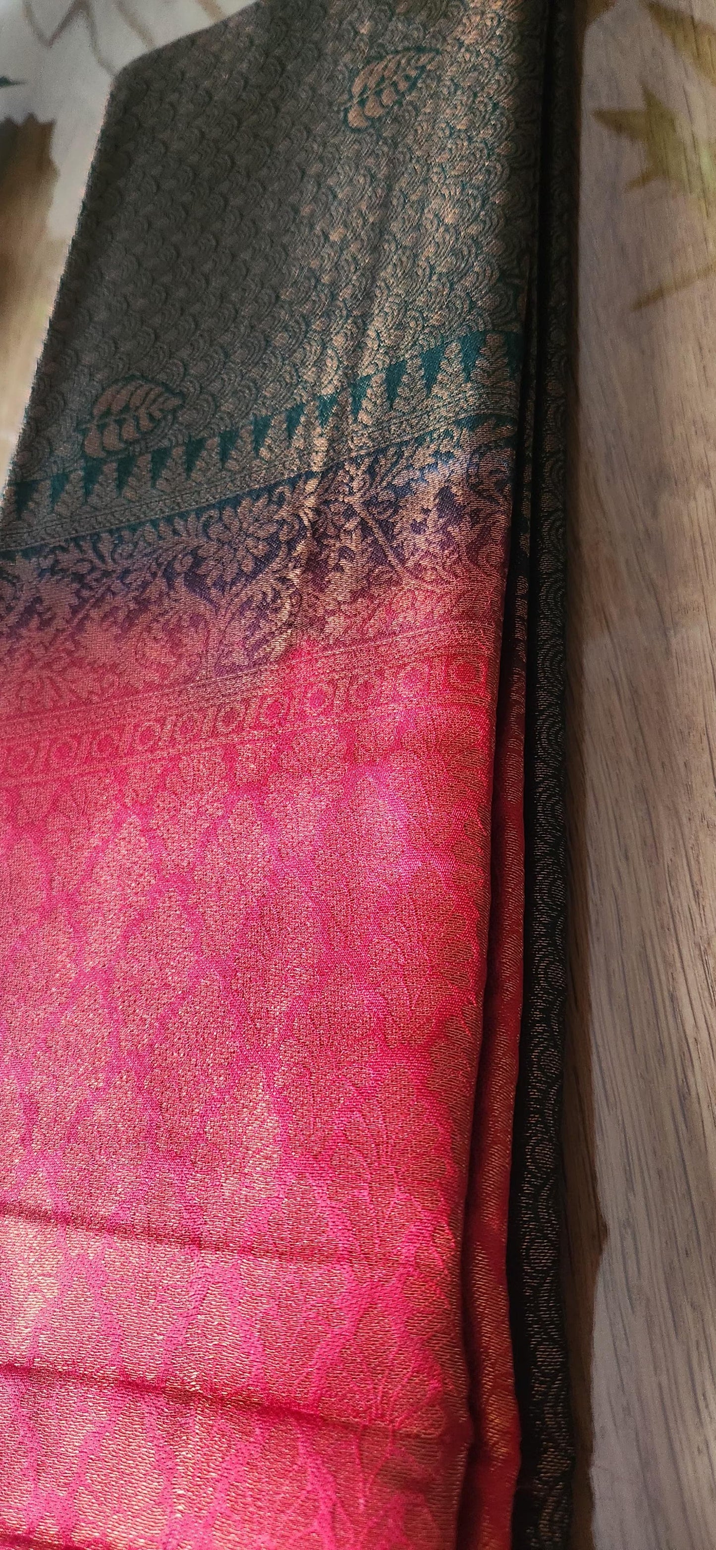 Kubera Silk Dual Weave Legacy Saree featuring a woven silk body with subtle self-patterns and a finely detailed traditional border, neatly styled on a wooden surface with classic décor.
