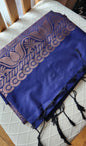 Deep navy blue silk saree with antique gold zari floral buttas and black tassels laid flat