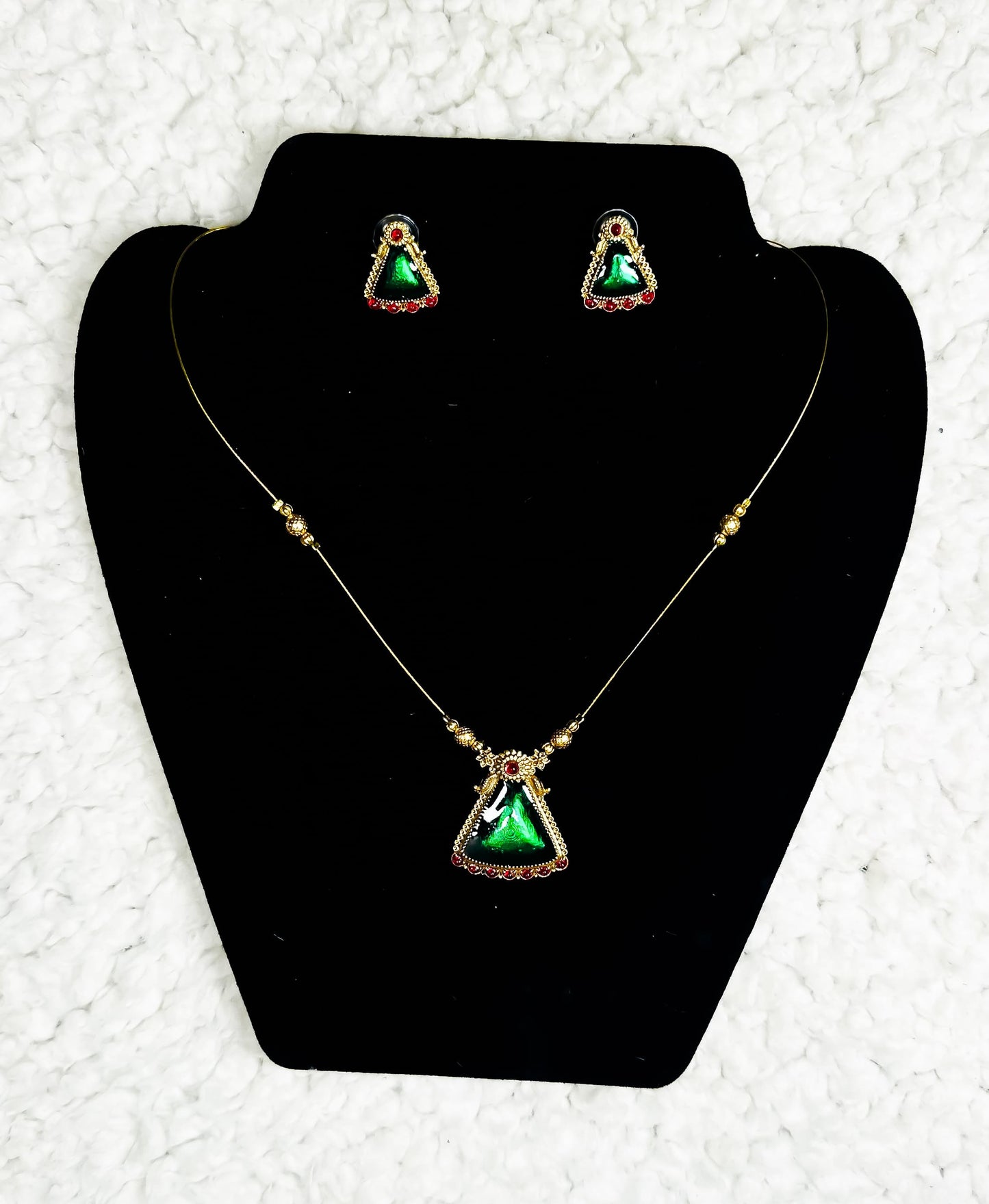 Gold triangle pendant necklace and earrings set with emerald green gemstone and delicate chain design