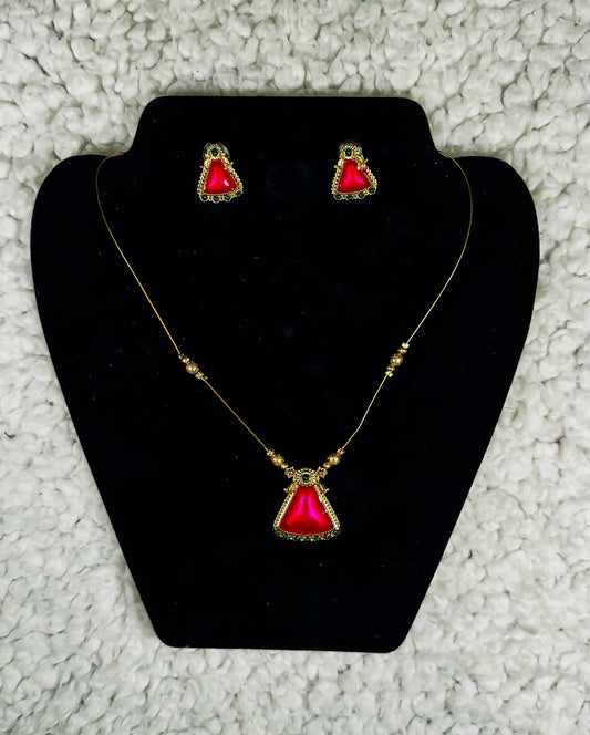 Gold triangle pendant necklace and earrings set with ruby red gemstone and ornate border detailing